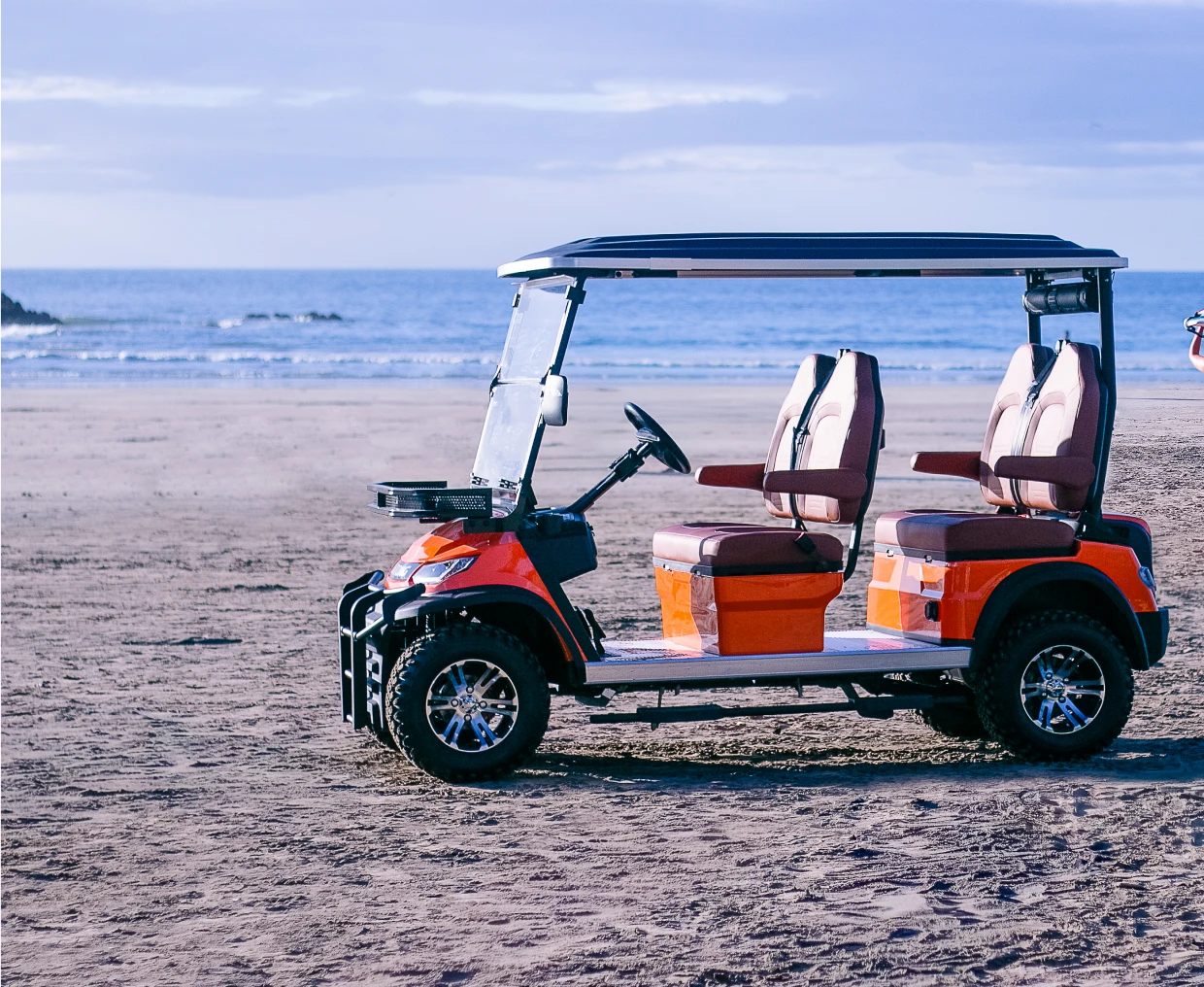Orange golf cart on sandy beach